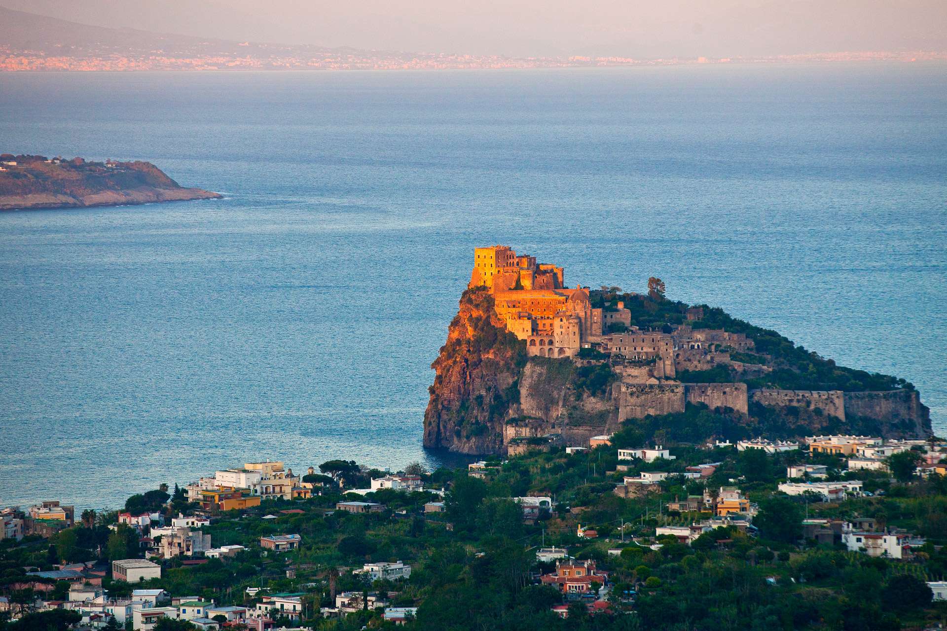 Il Castello Aragonese che si erge dal mare nell'ora dorata